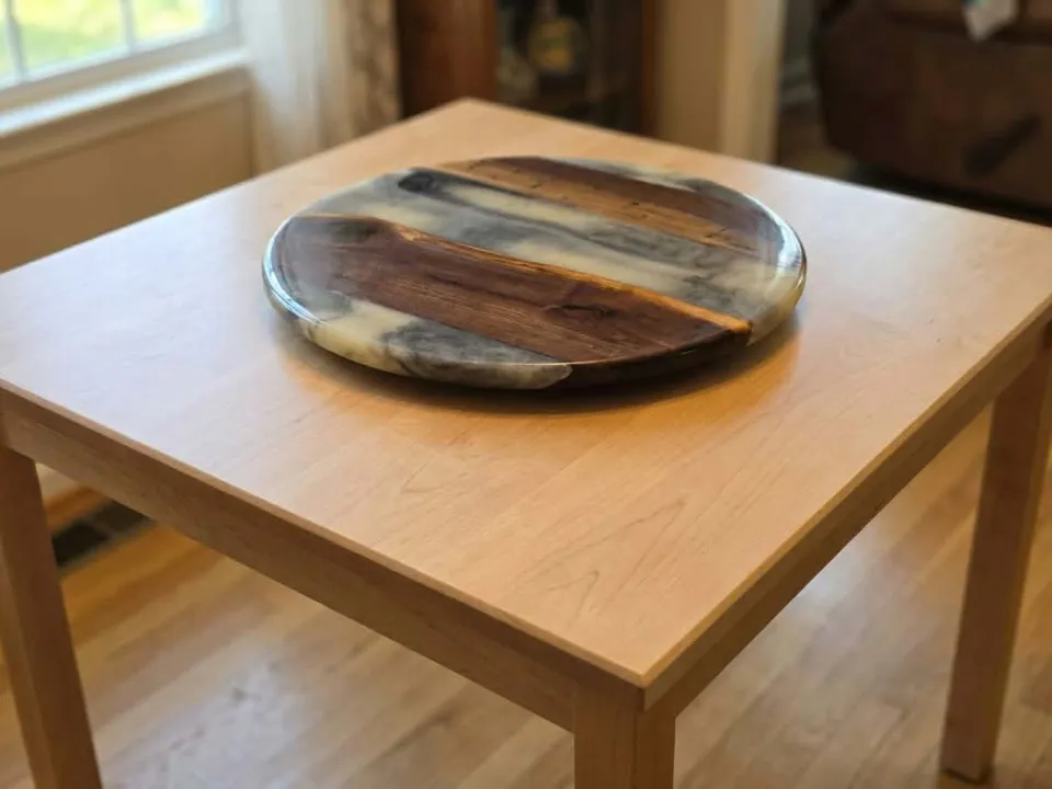 Walnut lazy susan with a white and gray epoxy pour, made in our shop, on a maple table